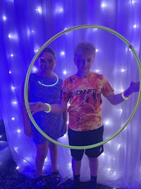 two children standing in front of a hula hoop