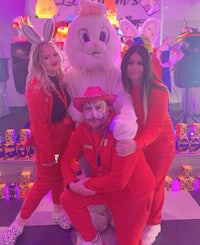 three people posing with an easter bunny